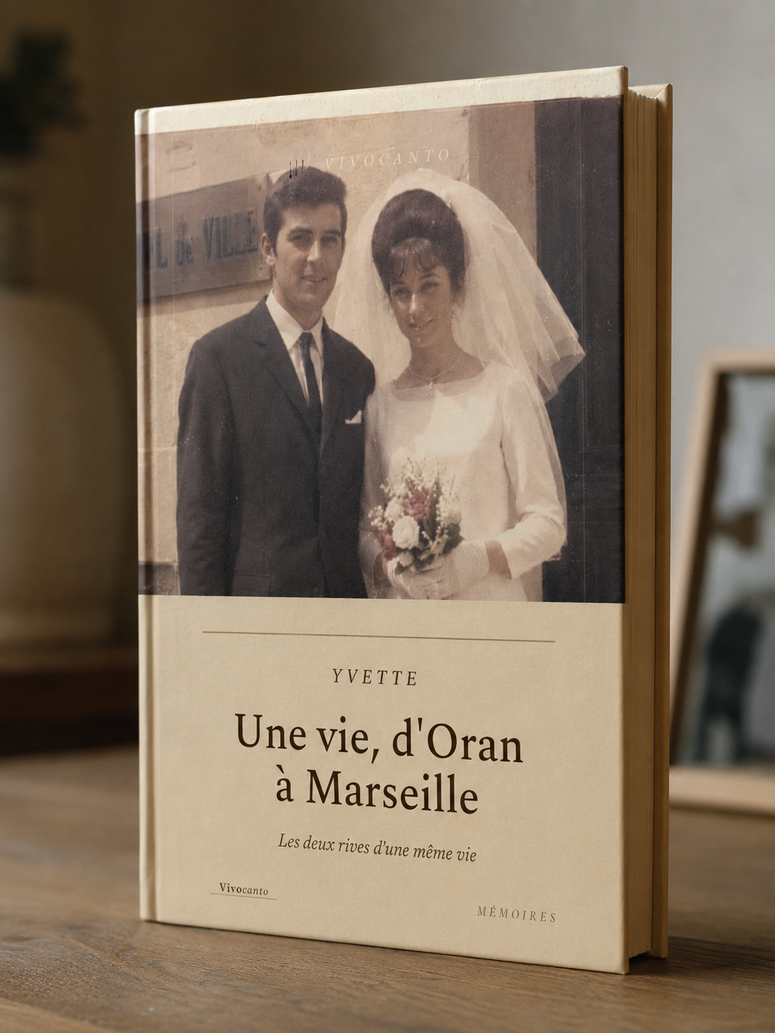 Le livre relié bordeaux posé sur un bureau, une photo de mariage des années 1960 glissée dessus.